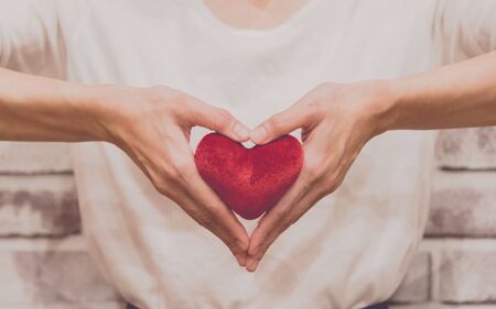 Close up of woman hands holding heart in love and valentine conceptの写真素材