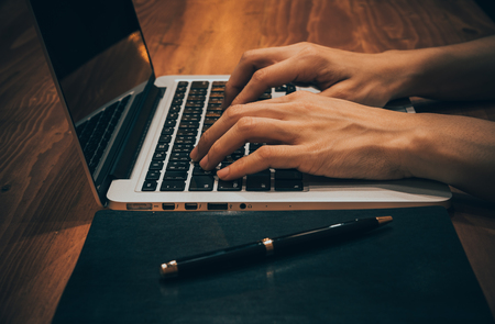 Business women work with  laptop,pen and notebook on the wooden tableの写真素材