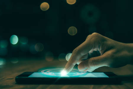 Close up of people hand using smartphone in technology and social concept with digital effectの写真素材