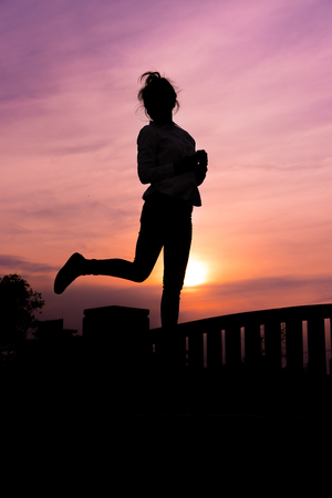 Silhouette of the women in the sunset with happy celebratingの写真素材