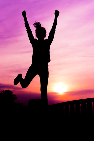 Silhouette of the women in the sunset with happy celebratingの写真素材