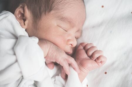 Newborn baby sleeping on bed.Family and love concept.Asian kid.の写真素材
