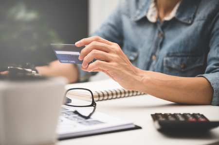 Close up of women's hand using laptop  for shopping online or payment with credit card.