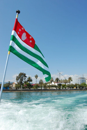 Flag of Abkhazia flying over the seaの写真素材