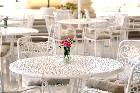 A bouquet of roses in a vase on a table in a summer cafeの写真素材