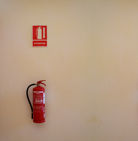 fire extinguisher under a warning sign in Coruna Spainの写真素材