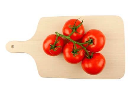 Cutting board with a branch of tomatoes isolated on whiteの写真素材