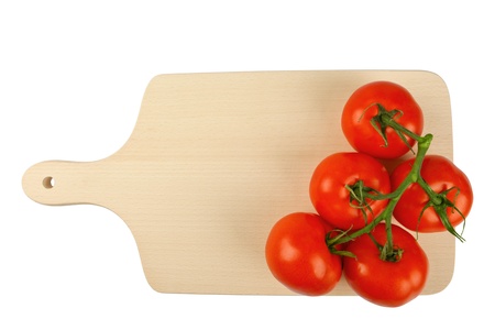 Cutting board with a branch of tomatoes isolated on whiteの写真素材