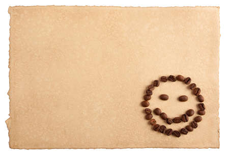 Childish smiley face symbol made from coffee crops on hand-made paper and isolated on white  Place for text の写真素材