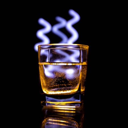A glass of drink illuminated with light paintingの写真素材