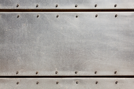 Old grungy, dirty and scratched metal plate with screwsの写真素材