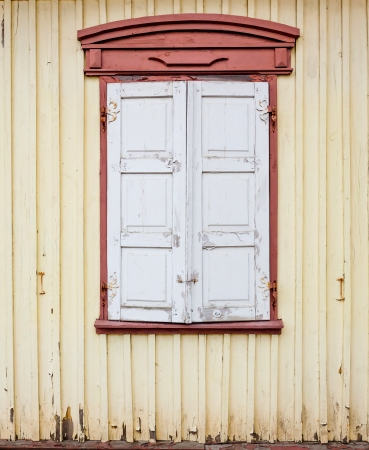 Detail of an old house wall with window and closed shuttersの写真素材