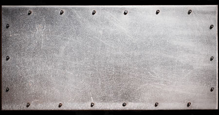 Old grungy, dirty and scratched metal plate with screwsの写真素材