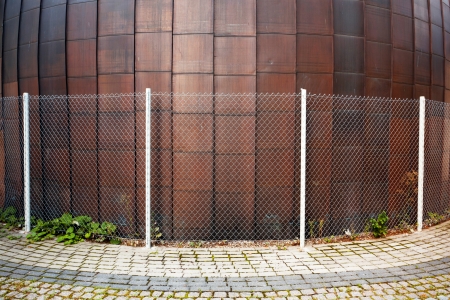 Copper round urban wall with a fence around itの写真素材
