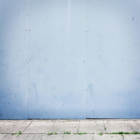 Simple urban wall with a sidewalk.の写真素材