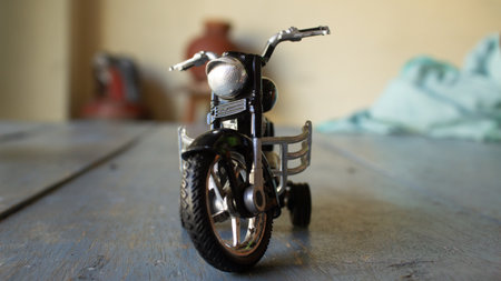 Vintage motorcycle toy on wooden table. Selective focus with shallow depth of field.の写真素材
