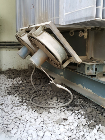 Power transformer have oil insulator leak from main tank on the rock wall and two fan circutation airの写真素材