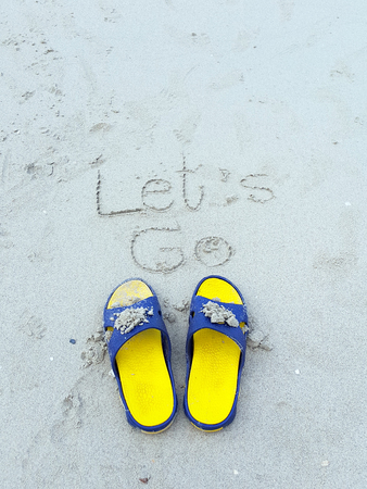 Let go word on the beach and yellow Sandalの写真素材