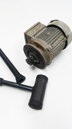 Electric motor with pinion gear and black hammer for Repair and Overhaul motor gear on white isolated backgroundの写真素材