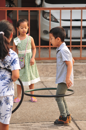 Boy and girl playing hoop on the street in townの写真素材