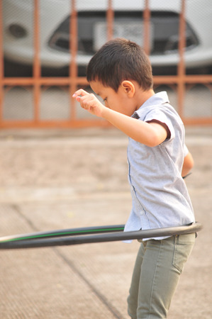 Boy and girl playing hoop on the street in townの写真素材