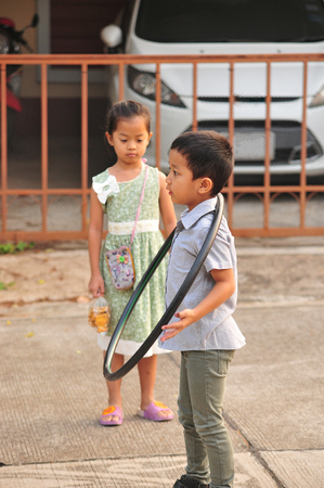 Boy and girl playing hoop on the street in townの写真素材