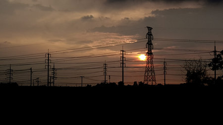 The sunset and High voltage electric pole silhouette