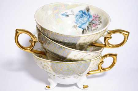 Antique tea cups stack, isolated on white. Beautiful porcelain.の写真素材