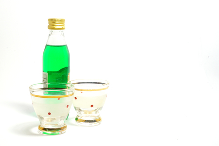 Small bottle of mint liqueur with two shot glassesの写真素材