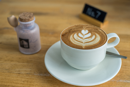 Hot coffee in a white cup on wooden table background.の写真素材