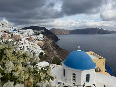 Image of white city on a slope of a hill at sunset, Oia, Santorini, Greeceの写真素材
