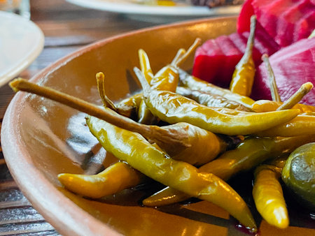 Pickled red and green peppers on a plate.の写真素材