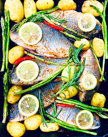 Grilled fish with potatoes, herbs and spices. Top view.の写真素材