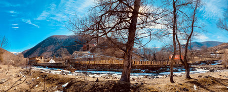 Panoramic view of the old wooden bridge over the river in the mountains.の写真素材