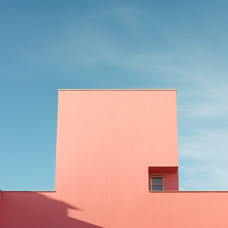 Modern apartment building exterior with pink walls and blue sky background. Architectural detail.の素材
