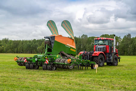 Russia, Leningrad Region - June, 2019: Powerful tractor brand Kirovets and Amazon brand seed drill at the exhibitionのeditorial素材
