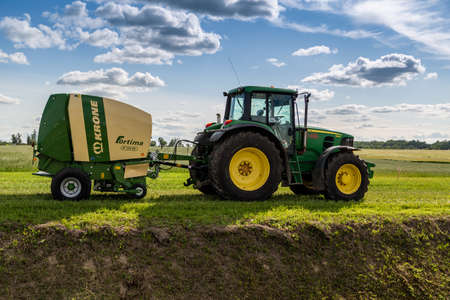 Russia, Leningrad Region - June, 2019: Powerful tractor brand JOHN DEERE and brand KRONE fortima at the exhibitionのeditorial素材