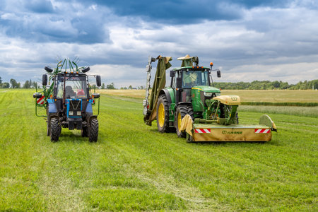 Russia, Leningrad Region - June, 2019: Powerful tractors brand JOHN DEERE and brand Krone at the exhibitionのeditorial素材
