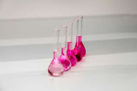 Composition of laboratory material with colored liquids in realistic glass potsの写真素材