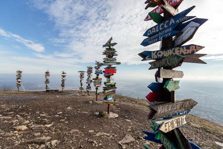 Caucasus, Pyatigorsk, Russia: Landscape on the mountain post with pointers cities and wooden bench on the peakのeditorial素材