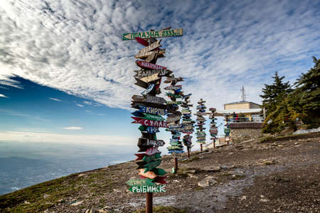 Caucasus, Pyatigorsk, Russia: Landscape on the mountain post with pointers cities and wooden bench on the peakのeditorial素材