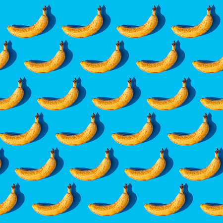 Colorful fruit pattern of fresh yellow bananas on blue background. From top viewの写真素材