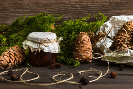 A jar of homemade jam made of pine cones on a dark backgroundの写真素材