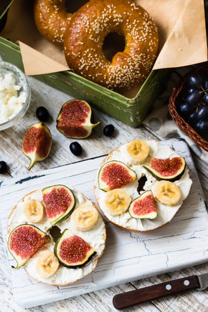 Bagels with fig and banana on curd cheese for breakfastの写真素材