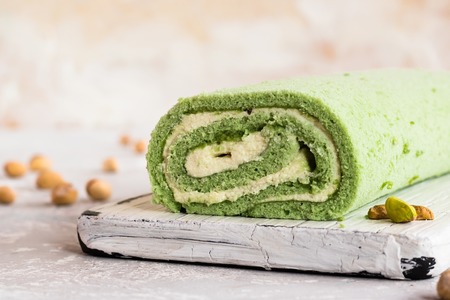 Biscuit pistachio roulette on white rustic boardの写真素材