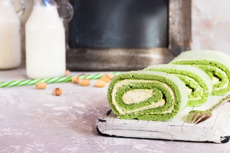 Biscuit pistachio roulette on white rustic boardの写真素材