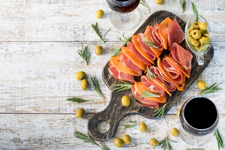 Sliced marbled ham and cheese with pumpkin seeds on rustic boardの写真素材