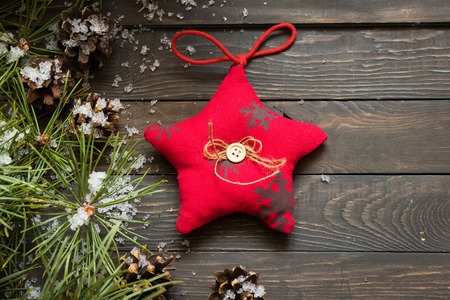 Christmas decorations and fur-trees branches under a snow on a dark wooden backgroundの写真素材