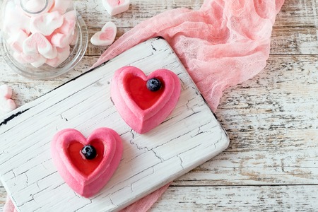 Two heart cakes on a white rustic boardの写真素材