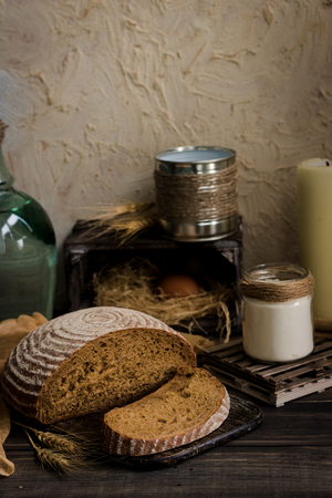 A loaf of bread on a leaven on a dark rustic backgroundの写真素材
